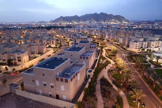 Knowledge Economic City residential villas and landscaped streets at dusk with the Madinah mountains behind